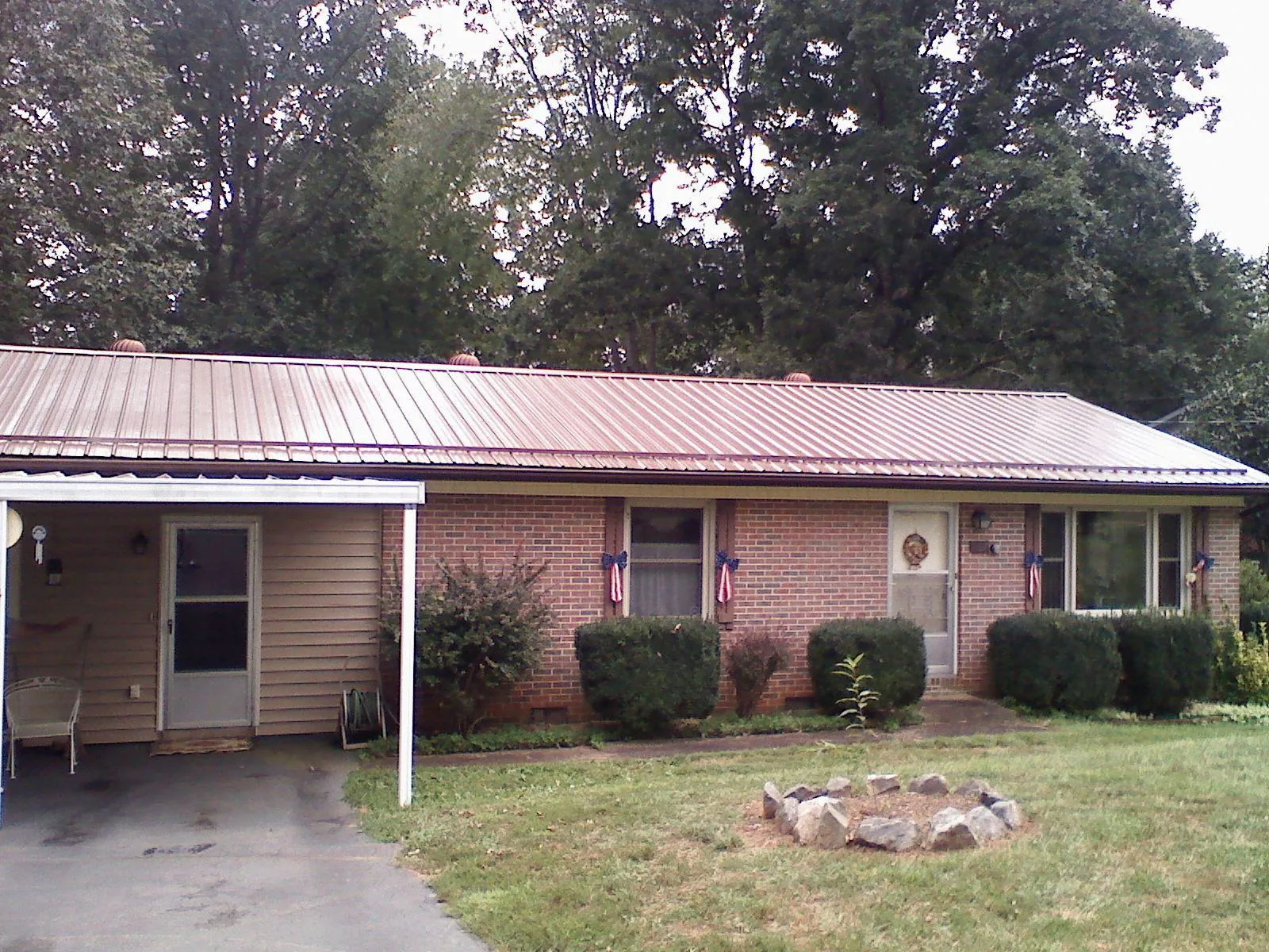 Bronze metal roof and carport on a brick ranch home — Roof Repair work by our crew in Palatka
